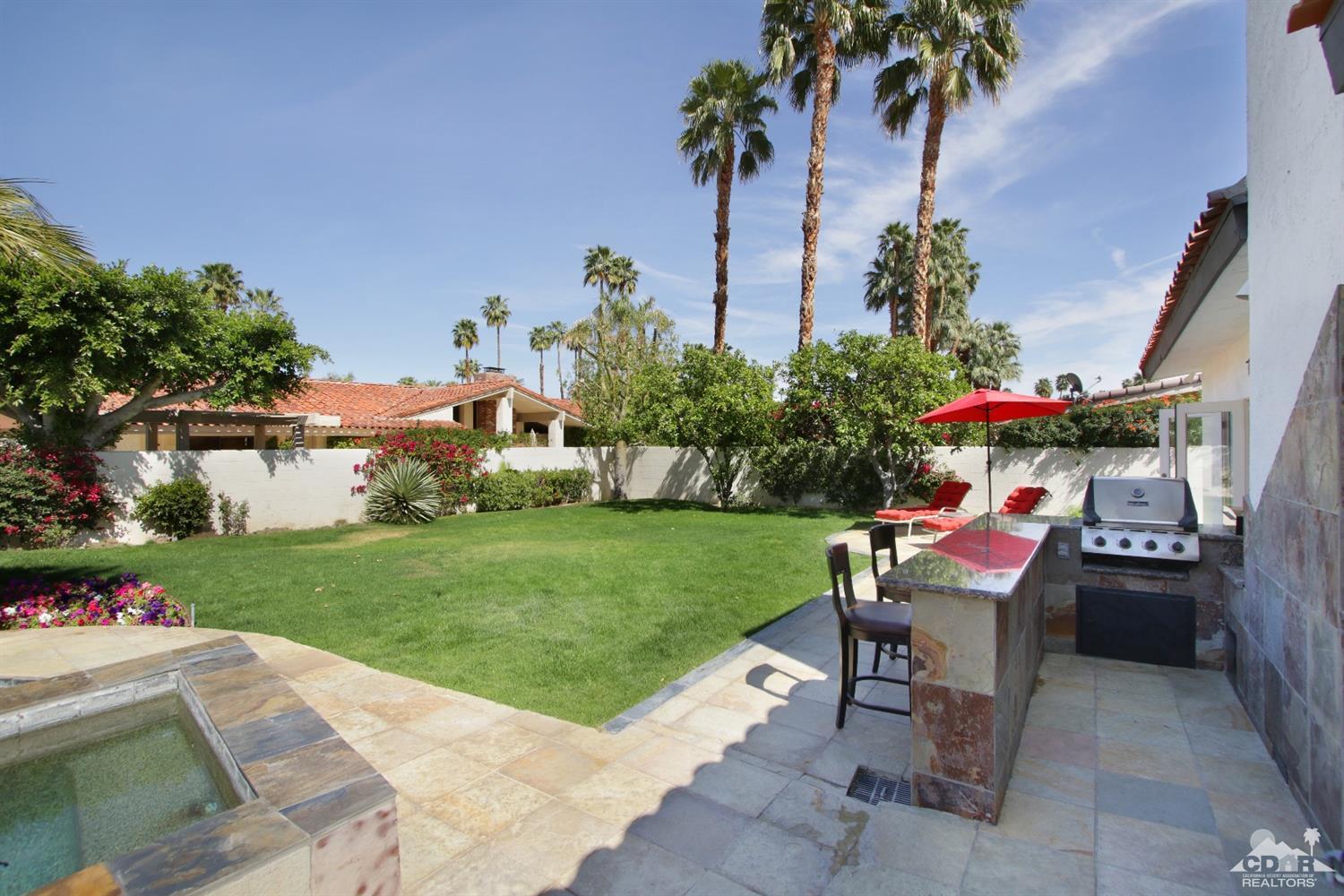 75570 Fairway Drive Indian Wells, CA 92210 - Photo 31 of 38 a view of a backyard with a table and chairs plants and palm trees