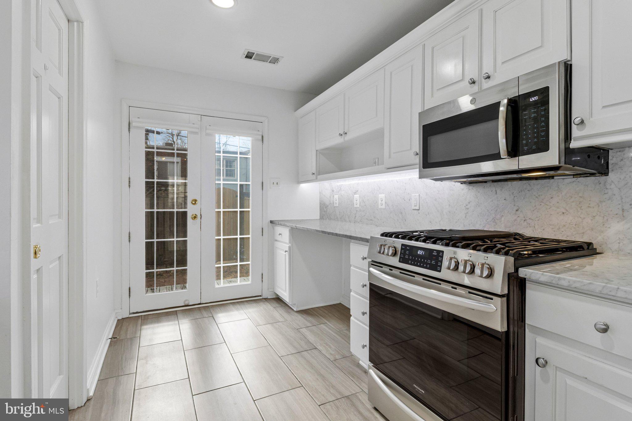 123 E Street Southeast Washington, DC 20003 - Photo 13 of 42 a kitchen with stainless steel appliances granite countertop a stove microwave and sink