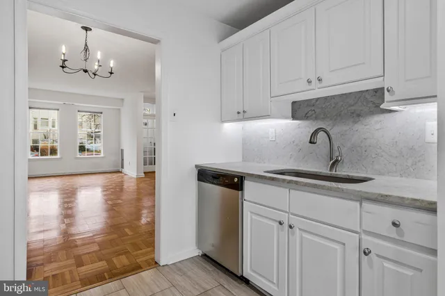 a kitchen with granite countertop white cabinets and stainless steel appliances