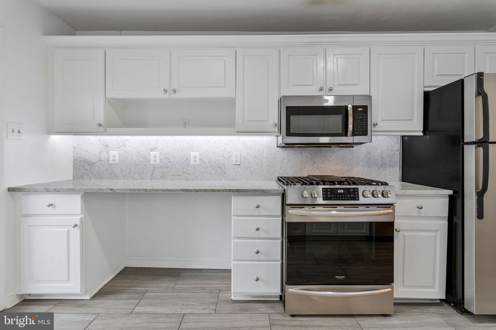 123 E Street Southeast Washington, DC 20003 - Photo 16 of 42 a kitchen with granite countertop white cabinets and stainless steel appliances