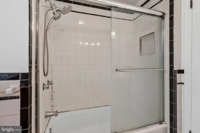 an empty room with chandelier fan and windows