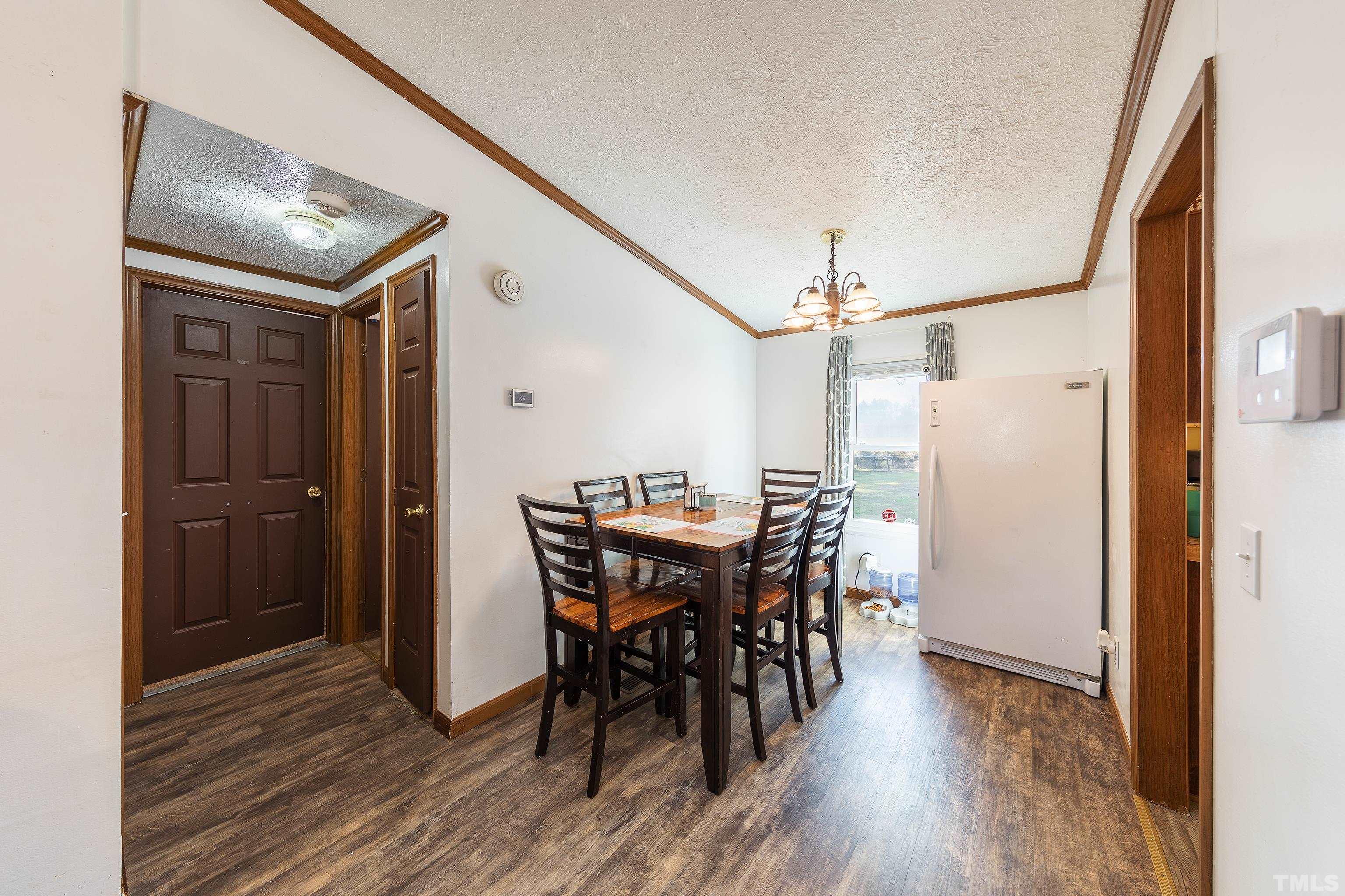 1469 Semora Road Roxboro, NC 27574 - Photo 8 of 22 a view of a dining room with furniture and wooden floor