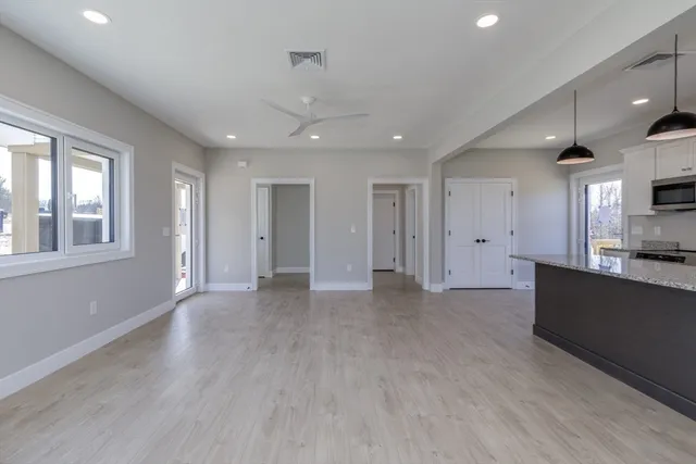 a living room with furniture a flat screen tv and kitchen view