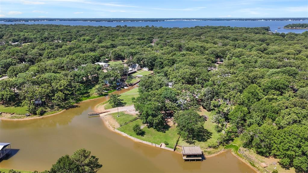 7110 Apache Circle Mabank, TX 75156 - Photo 33 of 39 Waterfront property featuring a private dock, expansive green spaces, mature tree coverage, and direct water access