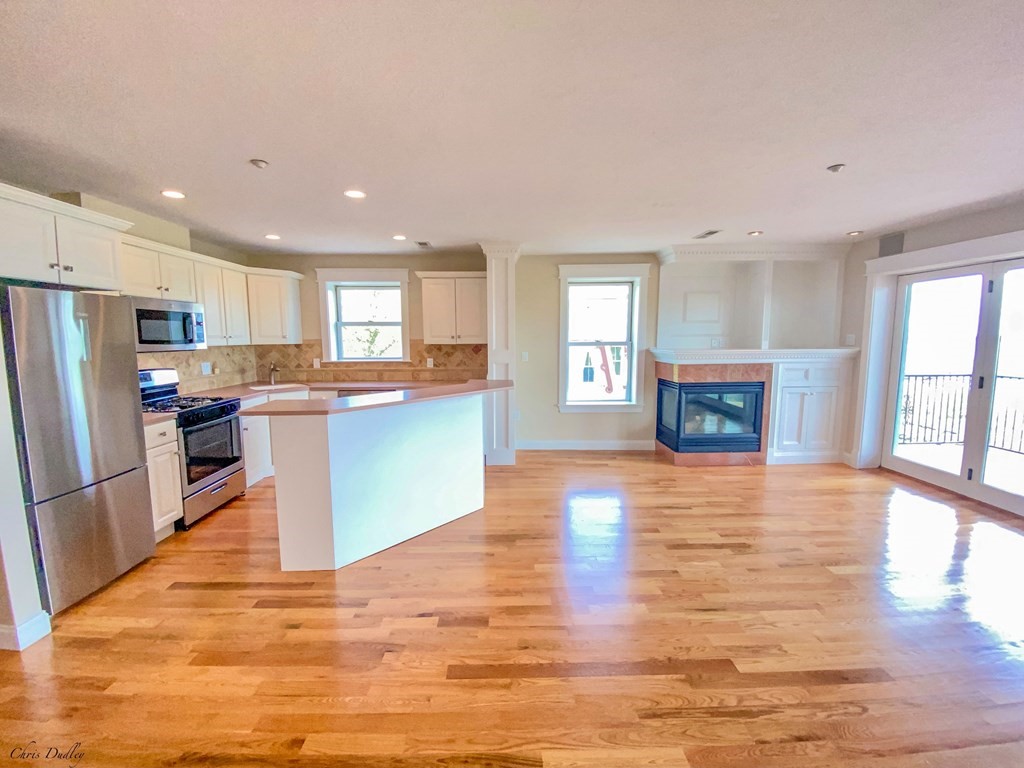 53 Thomas Park, Unit 9 Boston, MA 02127 - Photo 12 of 41 a kitchen with granite countertop wooden floors and stainless steel appliances