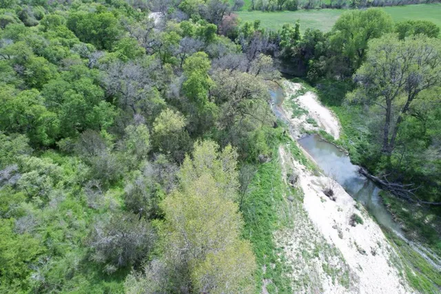 an aerial view of a houses with outdoor space and trees