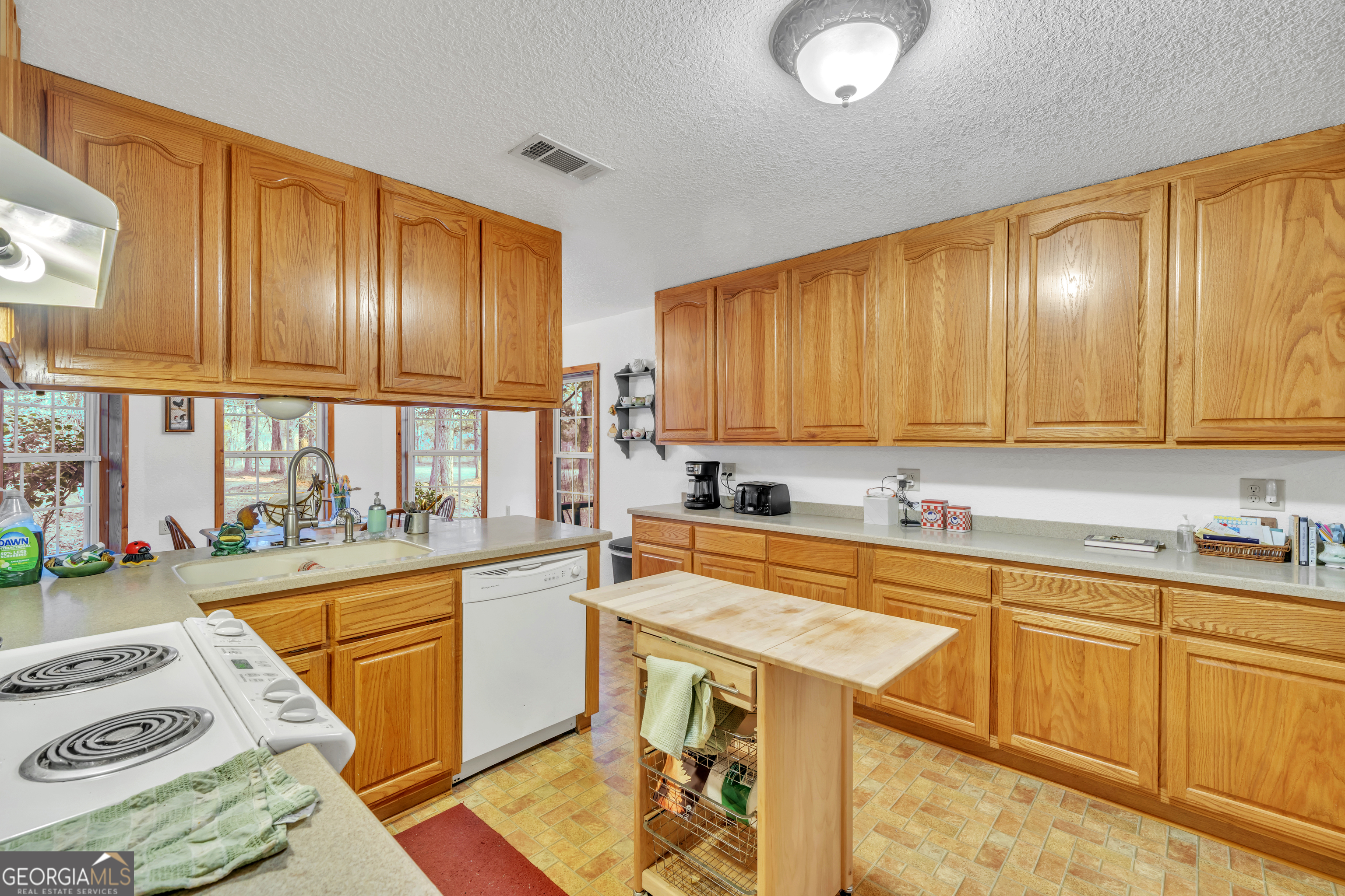 241 Foskey Cemetery Road Adrian, GA 31002 - Photo 22 of 95 a kitchen with a sink a stove cabinets and a dining table