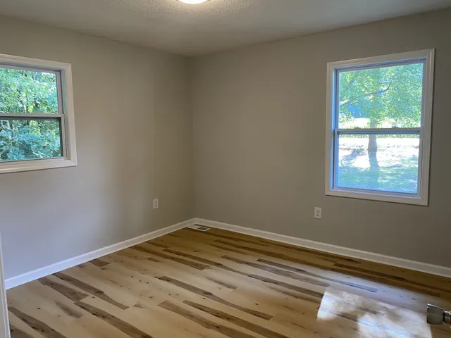a view of a room with wooden floor and windows