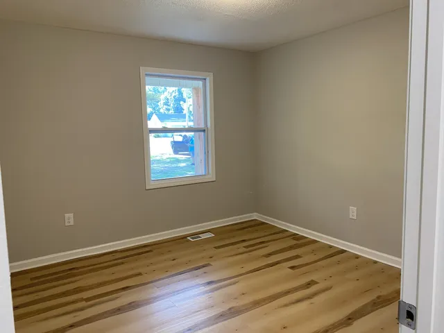 a view of a room with wooden floor and window
