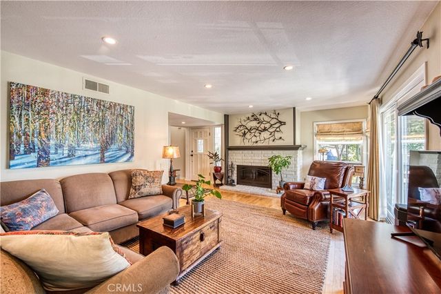 a living room with furniture fireplace and a large window