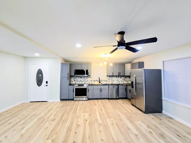 a kitchen with stainless steel appliances kitchen island granite countertop a refrigerator and a stove top oven