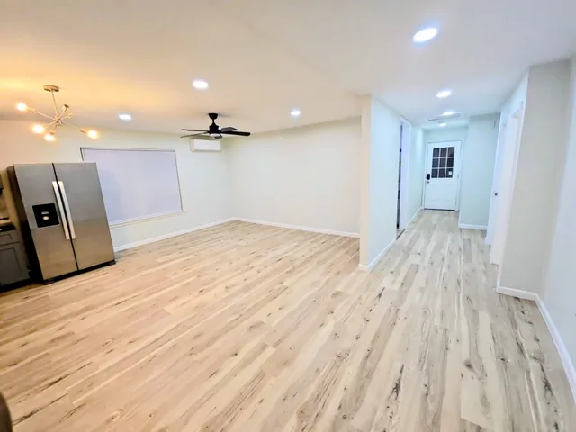 a view of a kitchen with wooden floor and a ceiling fan