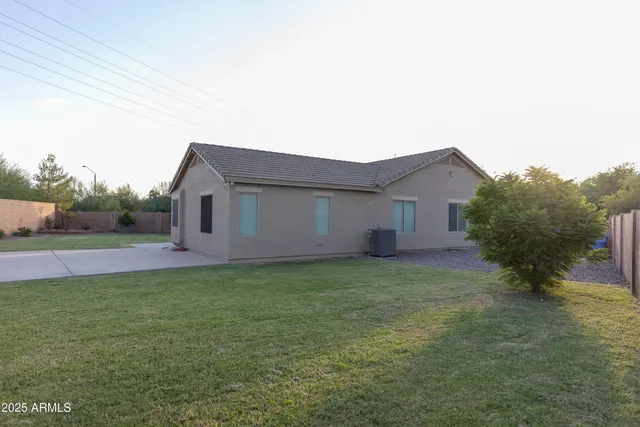 a view of a house with backyard and bushes