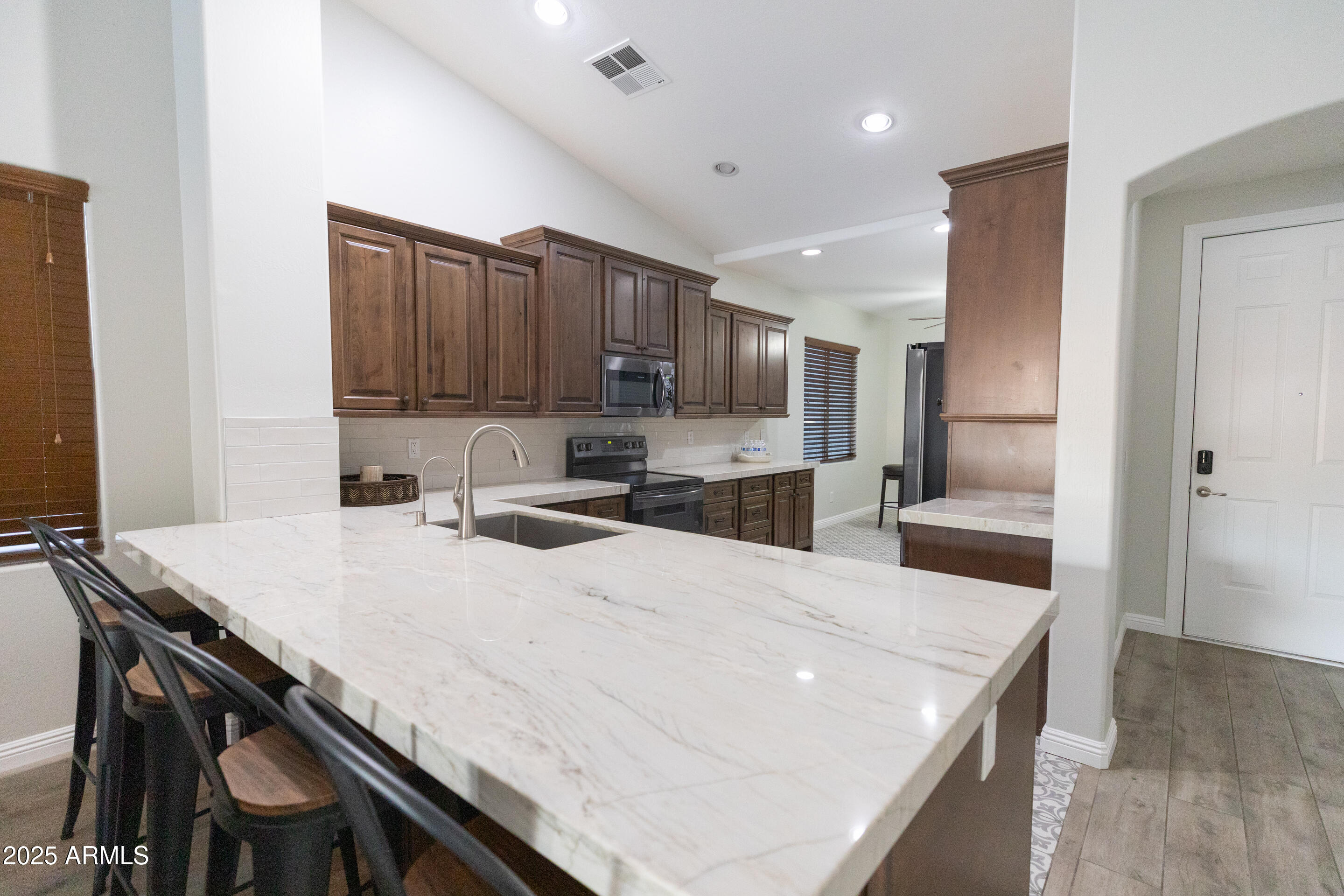 4759 South Granite Street Gilbert, AZ 85297 - Photo 5 of 29 a kitchen with kitchen island a stove a table and chairs in it