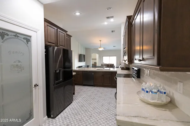 a kitchen with stainless steel appliances granite countertop a sink dishwasher stove and cabinets with wooden floor
