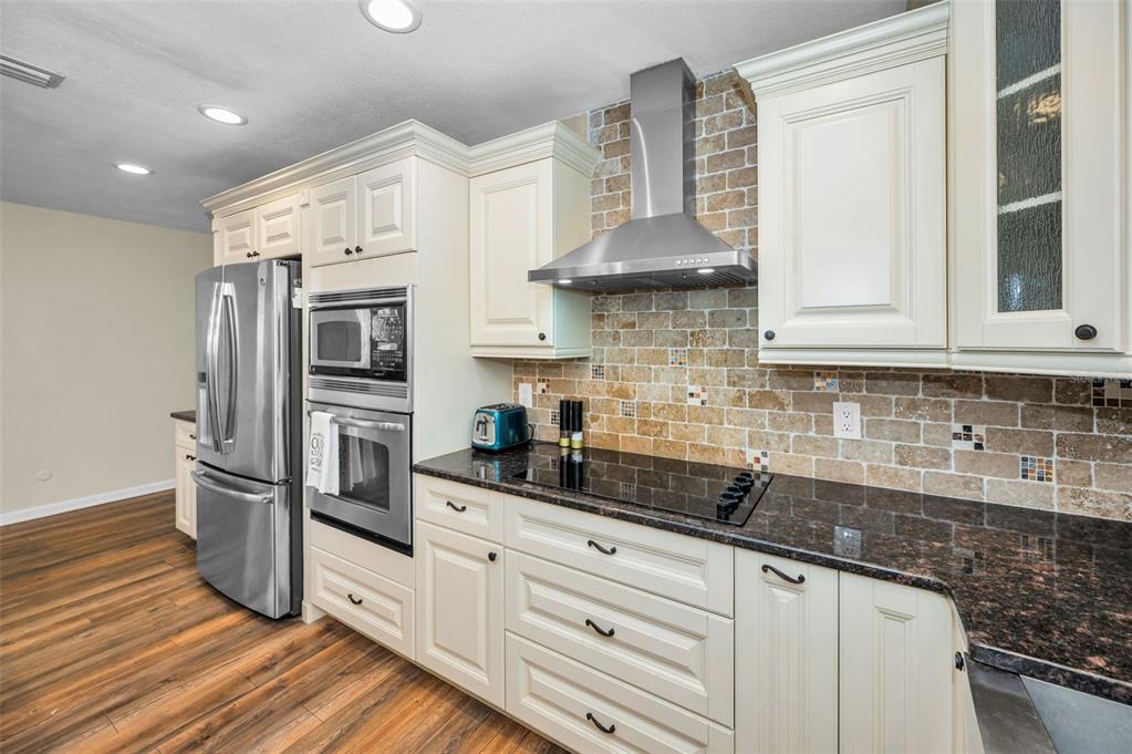 11077 87th Avenue Seminole, FL 33772 - Photo 5 of 32 a kitchen with stainless steel appliances granite countertop a sink a stove and a refrigerator