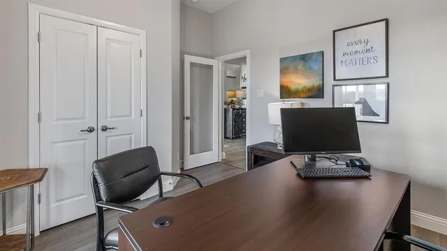 a view of a workspace with furniture and a window