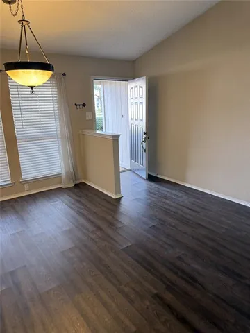 an empty room with wooden floor and door