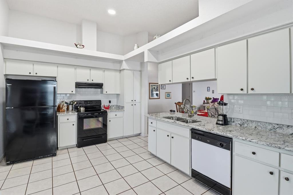 1046 Castille Drive Spring Hill, FL 34608 - Photo 14 of 44 a kitchen with stainless steel appliances a sink stove refrigerator and cabinets