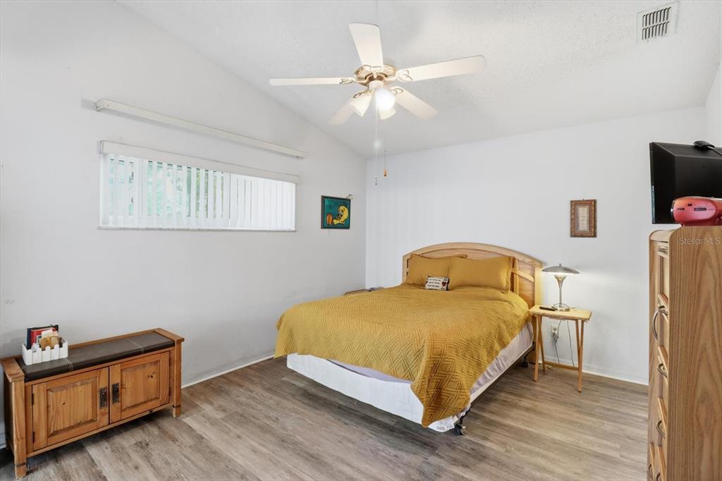 1046 Castille Drive Spring Hill, FL 34608 - Photo 19 of 44 a bedroom with a bed and wooden floor