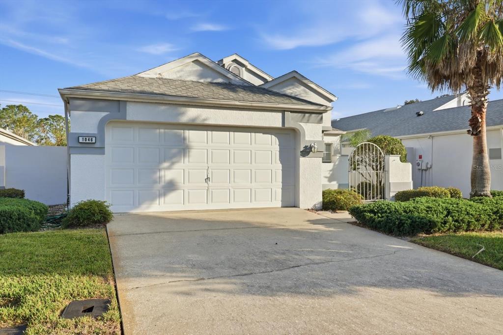 1046 Castille Drive Spring Hill, FL 34608 - Photo 2 of 44 a front view of a house with a yard and garage