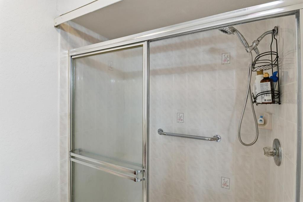 1046 Castille Drive Spring Hill, FL 34608 - Photo 24 of 44 a bathroom with a glass shower door
