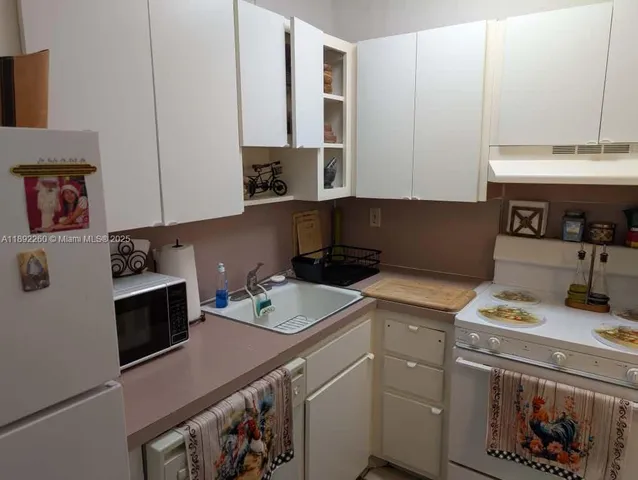 a kitchen with a sink a stove and cabinets