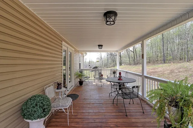 a view of a patio with table and chairs with wooden floor and fence
