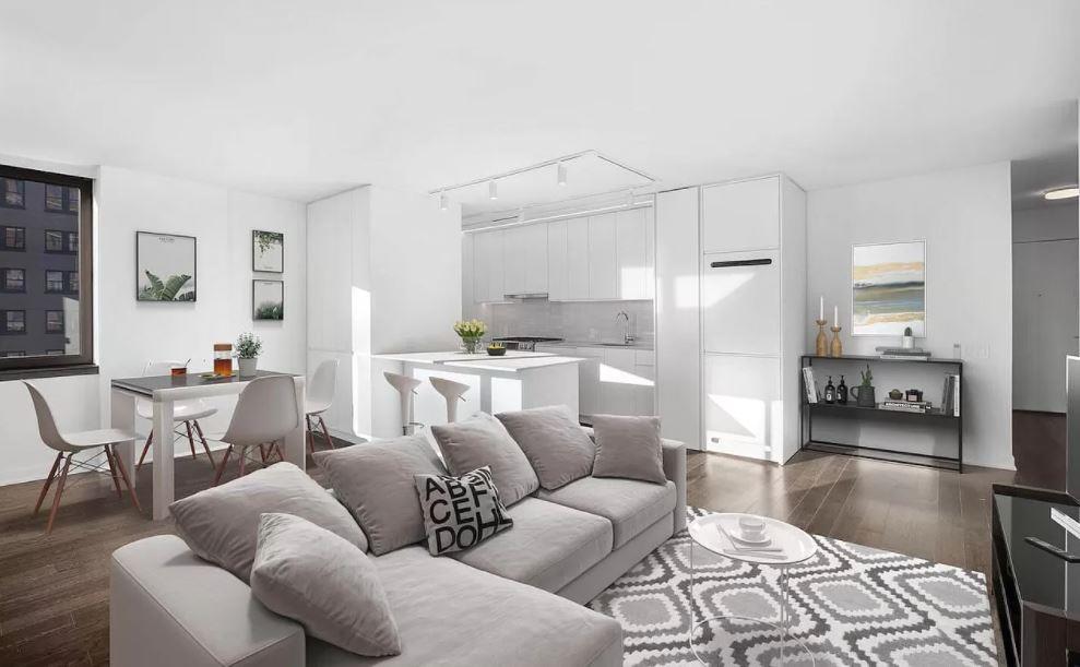 a living room with furniture white walls and kitchen view