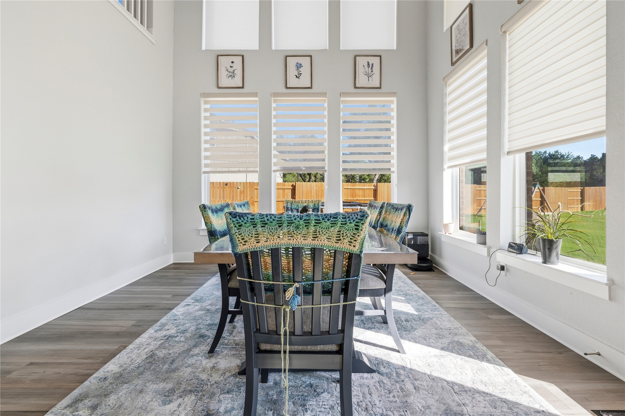105 Autumn Oak Way Georgetown, TX 78628 - Photo 9 of 40 Dining space featuring high ceilings, wood-finish flooring, a wall of tall windows with blinds, and white baseboards