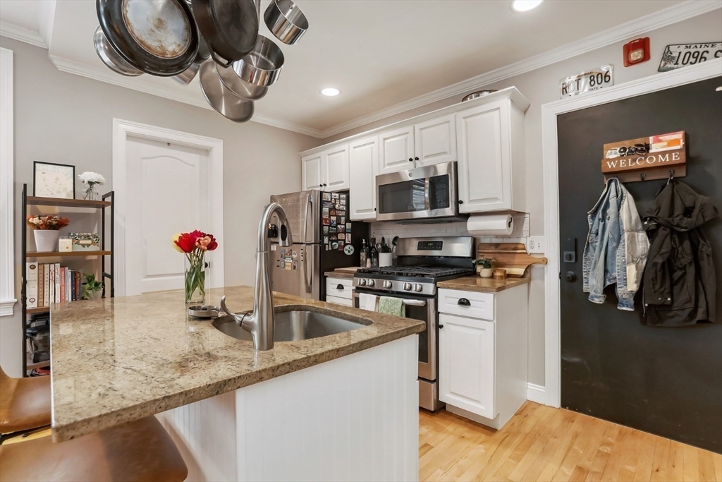 454 Hanover Street, Unit 4 Boston, MA 02113 - Photo 11 of 23 a kitchen with stainless steel appliances granite countertop a sink and a refrigerator