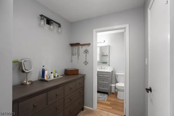a bathroom with a granite countertop sink mirror and toilet