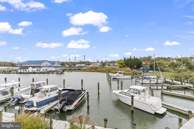 a kitchen with stainless steel appliances granite countertop a refrigerator a stove top oven and a view of living room