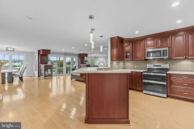 a kitchen with granite countertop a refrigerator stove and sink