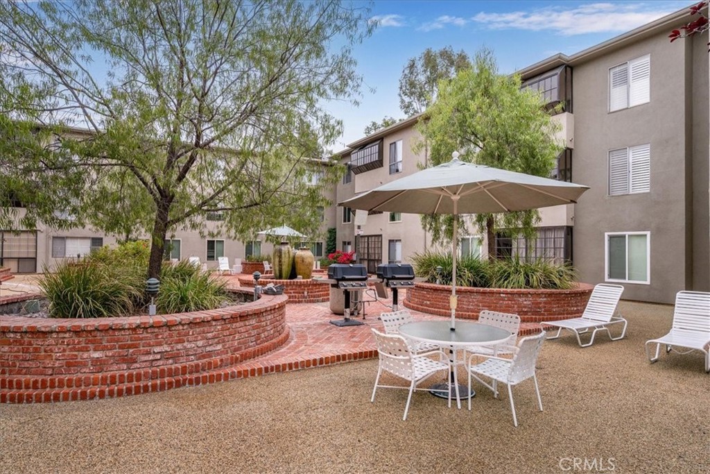 330 South Mentor Avenue, Unit 202 Pasadena, CA 91106 - Photo 3 of 16 a view of a patio with a table and chairs under an umbrella
