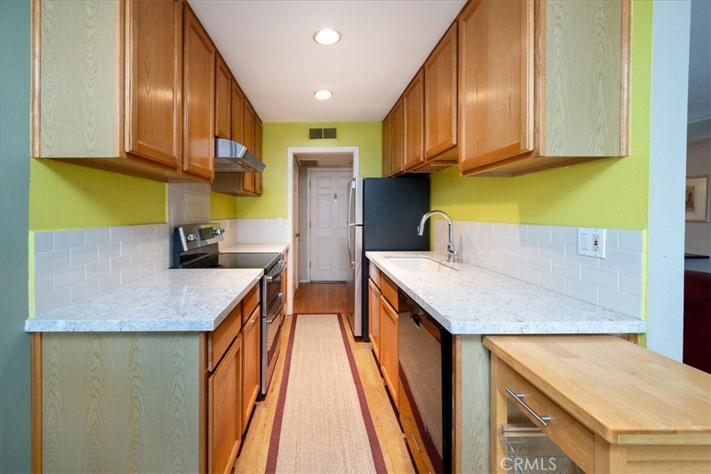 330 South Mentor Avenue, Unit 202 Pasadena, CA 91106 - Photo 10 of 16 a kitchen with stainless steel appliances granite countertop a sink and a refrigerator