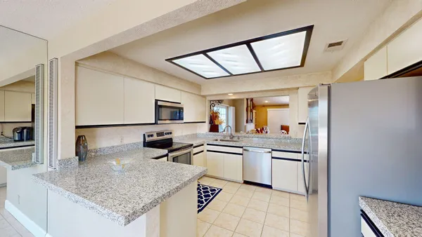 a kitchen with stainless steel appliances granite countertop a sink stove and cabinets