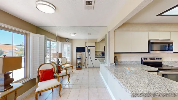 a living room with furniture a flat screen tv and large window