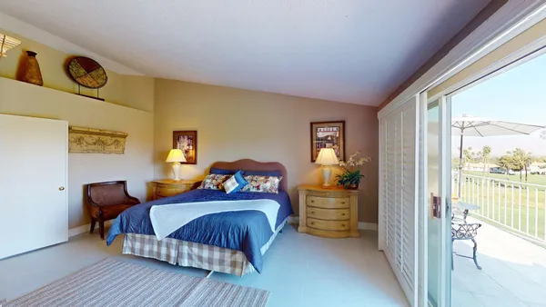 a bedroom with a bed and a dresser next to a window