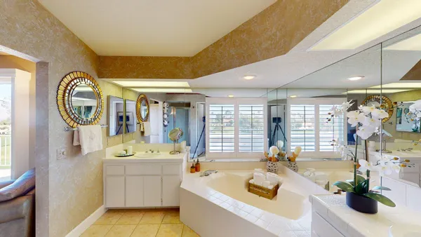 a spacious bathroom with a tub sink and mirror