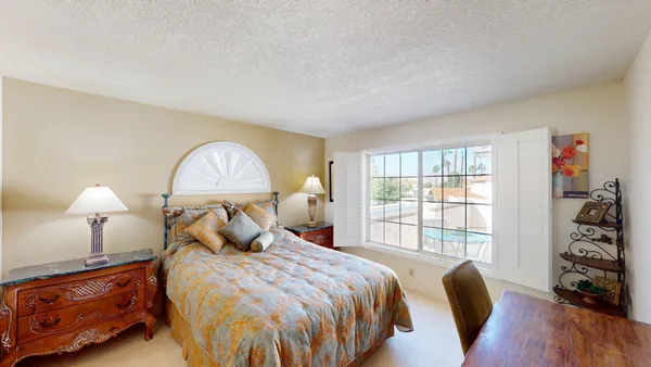 a bed room with a bed mirror and a lamp