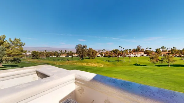 a view of a golf course with a car parked in the background