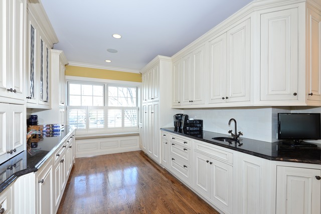268 Ridge Avenue Winnetka, IL 60093 - Photo 9 of 26 a kitchen with granite countertop white cabinets and black stainless steel appliances