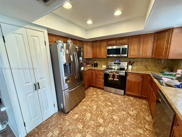 a kitchen with stainless steel appliances granite countertop a refrigerator stove and sink