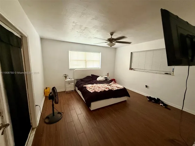 a bedroom with a bed and a flat tv screen on the dresser