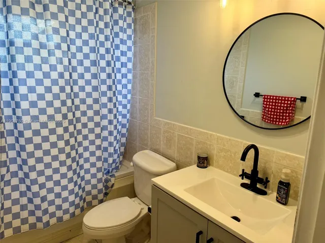 a bathroom with a sink mirror vanity and toilet