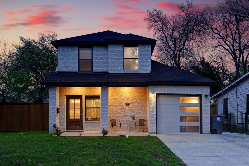 a view of a house with brick walls and a yard with wooden fence