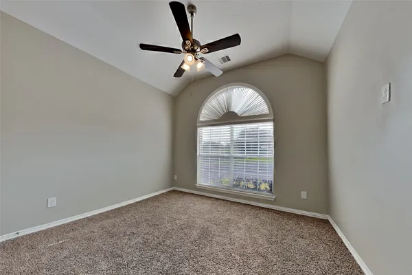 an empty room with windows and fan