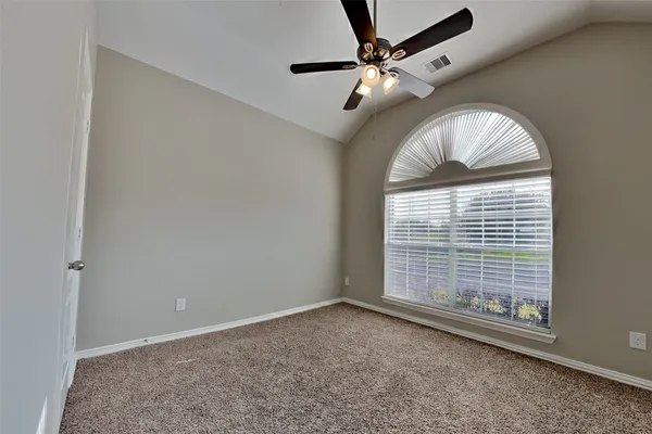 an empty room with windows and fan