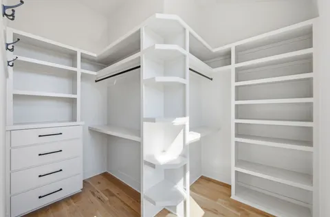 a view of walk in closet with empty racks